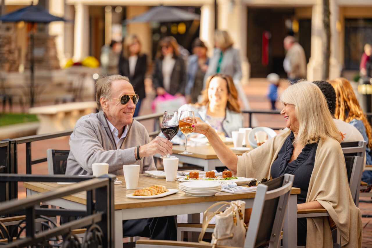 Two individuals enjoying a meal outdoors at Legacy Village